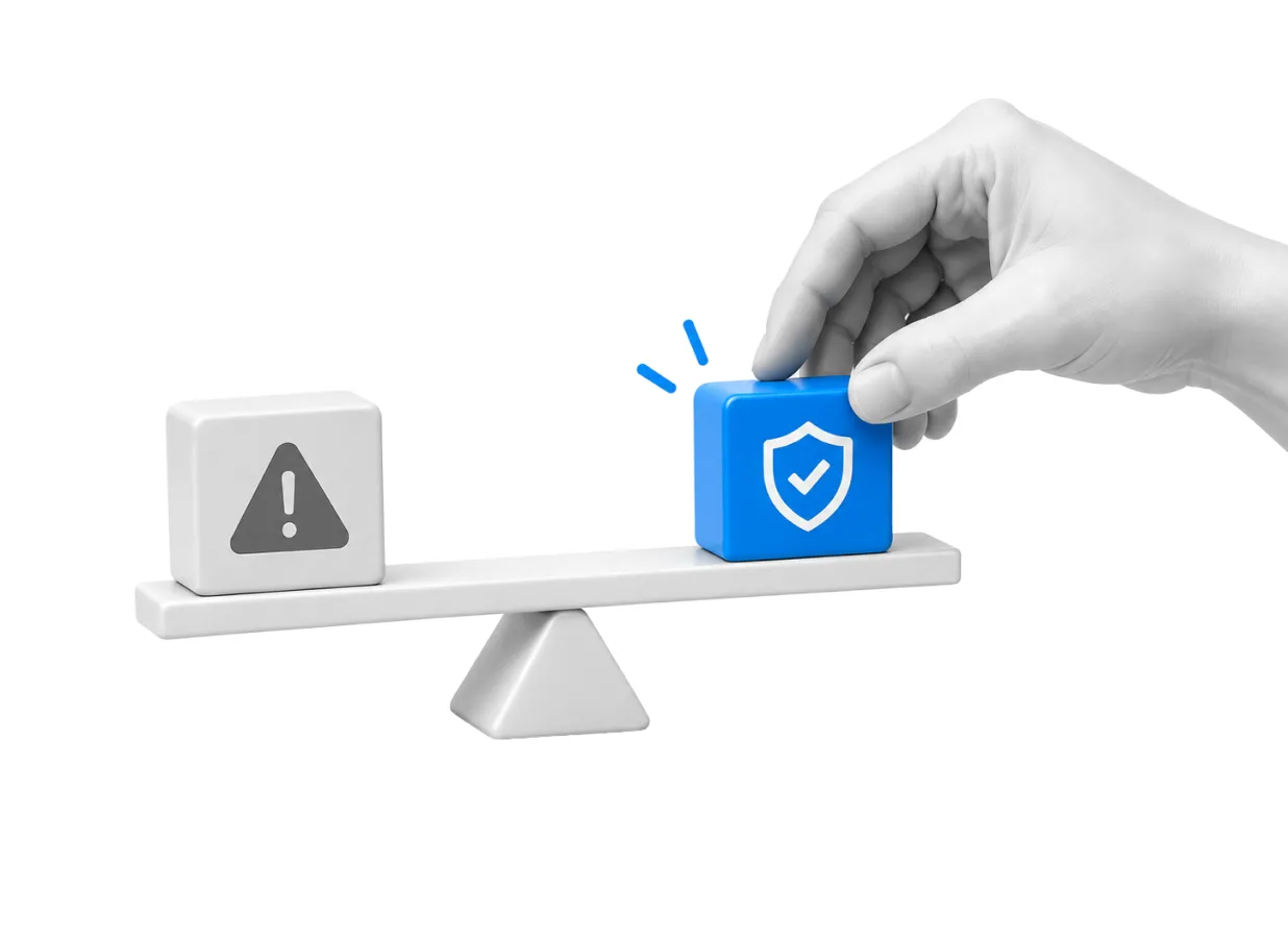 A hand balancing a blue shield icon against a warning sign on a set of scales