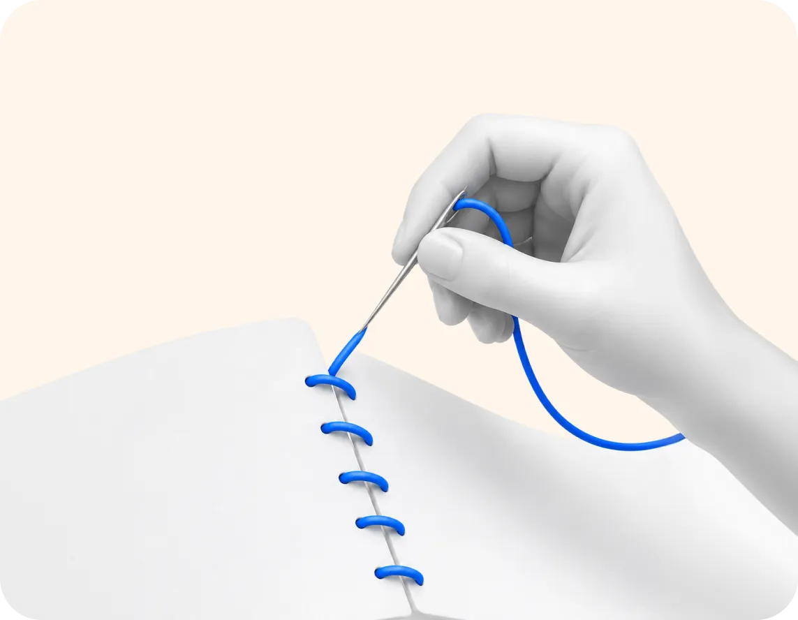 A hand stitching a blue thread through a white surface