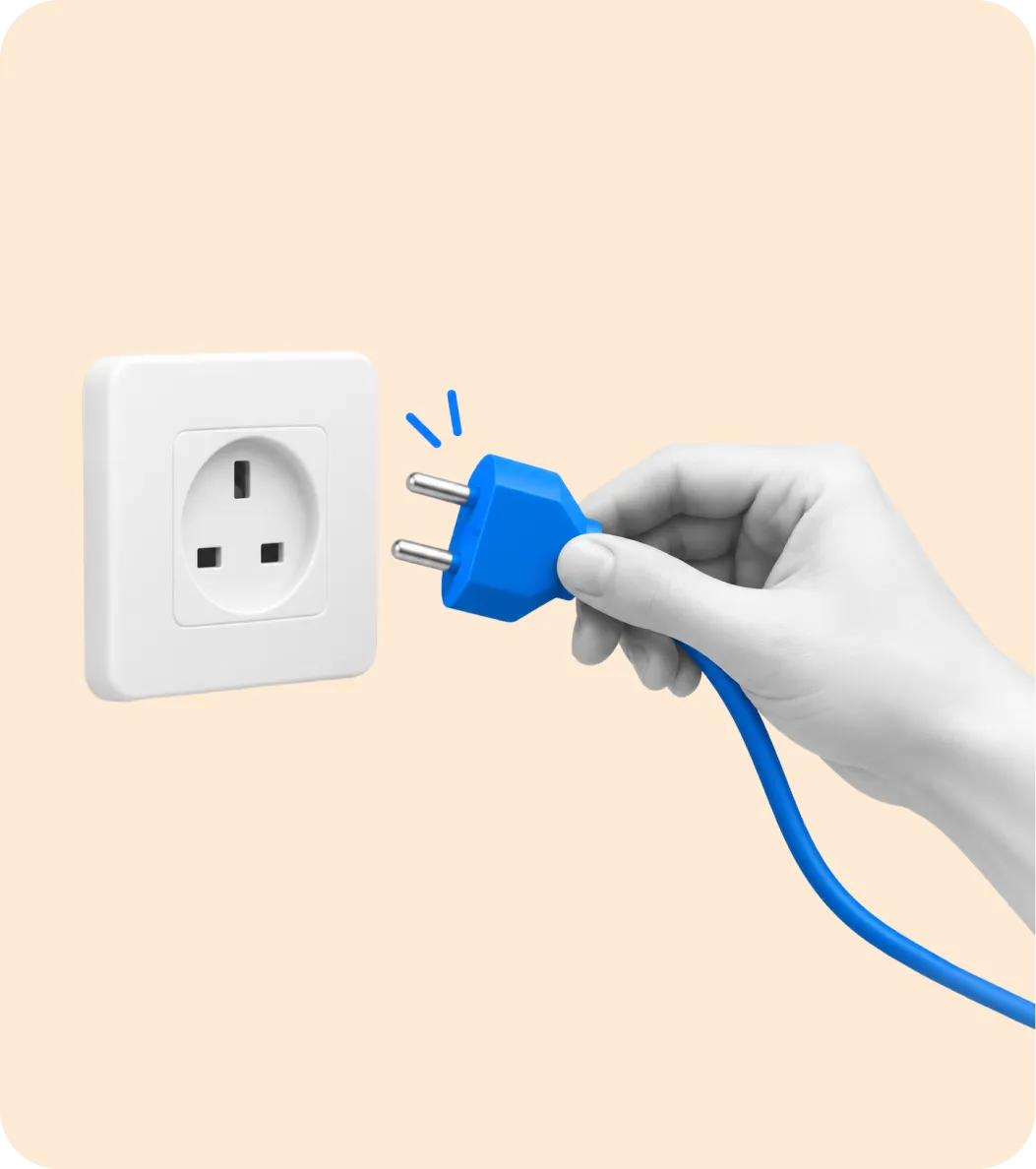 A hand holding a blue plug beside a wall socket