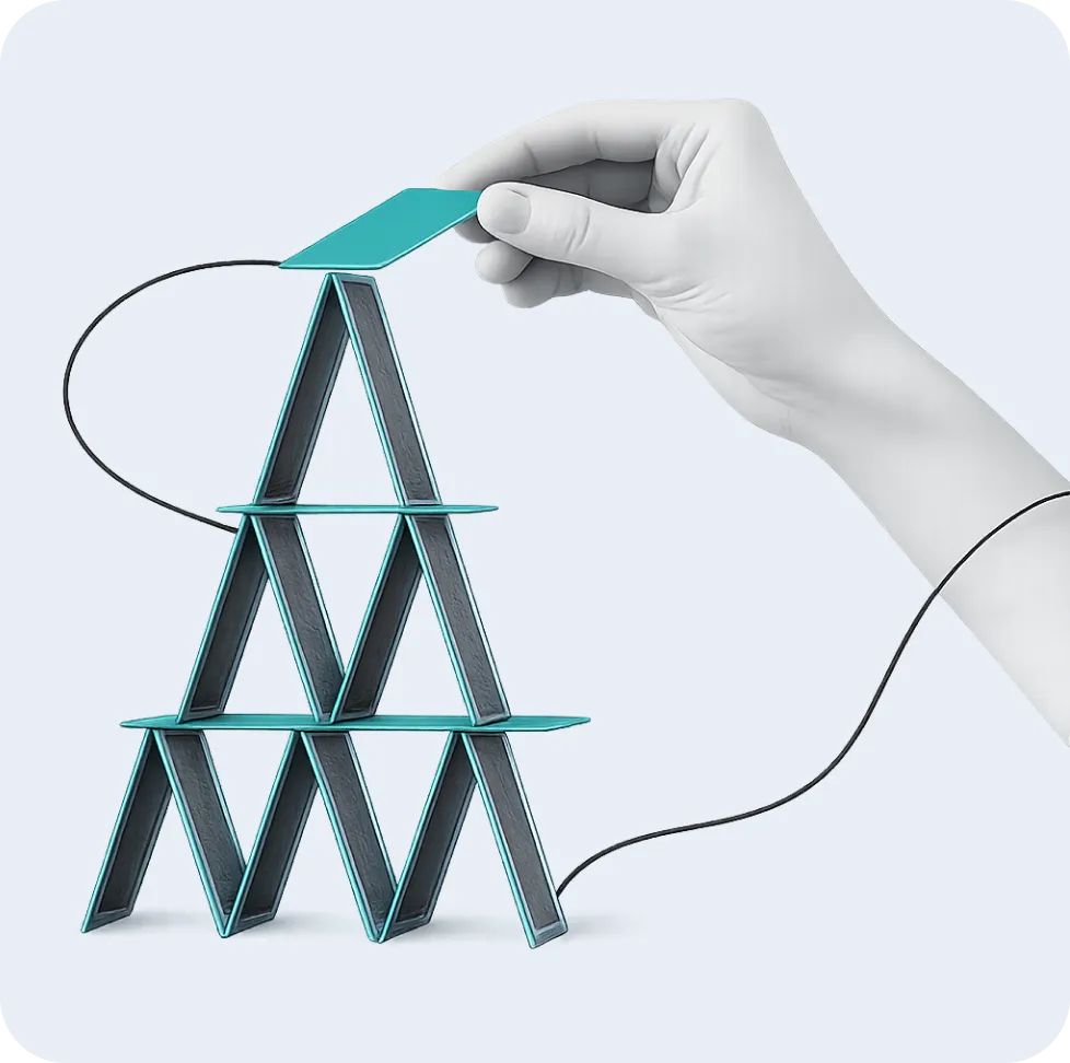 A hand placing the top card on a fragile house of cards