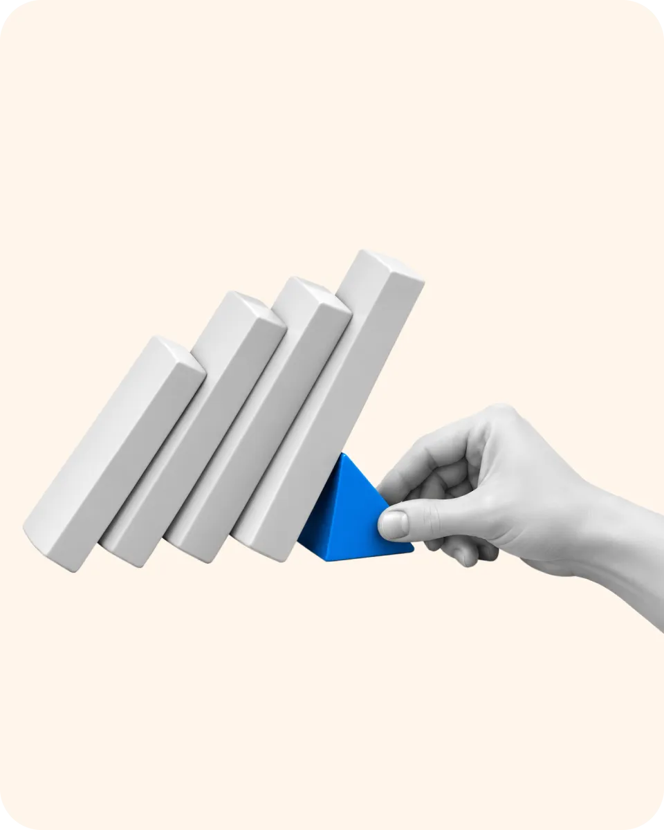 A hand holding back a row of falling dominoes